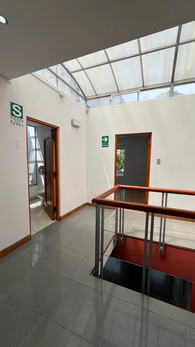 Hall del segundo nivel con techo de vidrio y luz natural