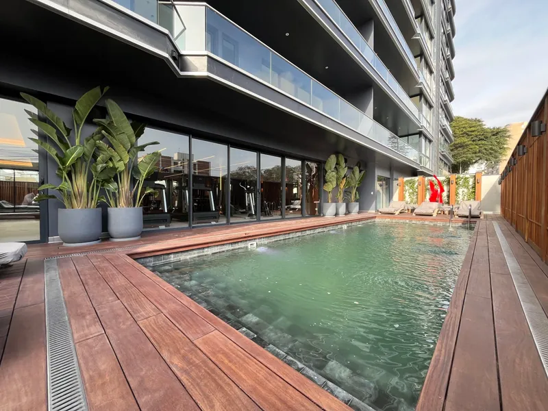 Piscina temperada del edificio con deck de madera