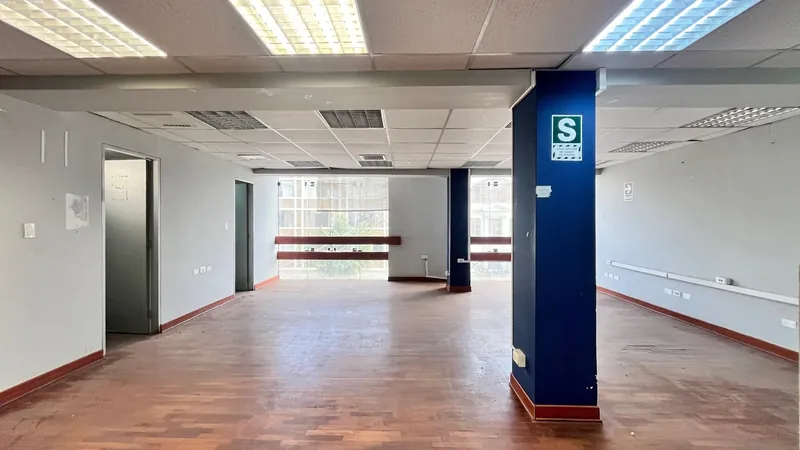 Salón amplio con ventanal hacia la avenida