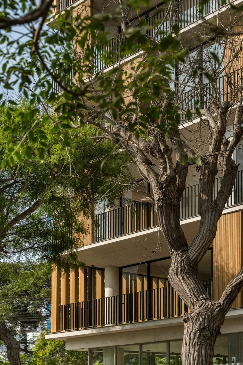 Fachada del edificio con concreto expuesto y paneles de madera